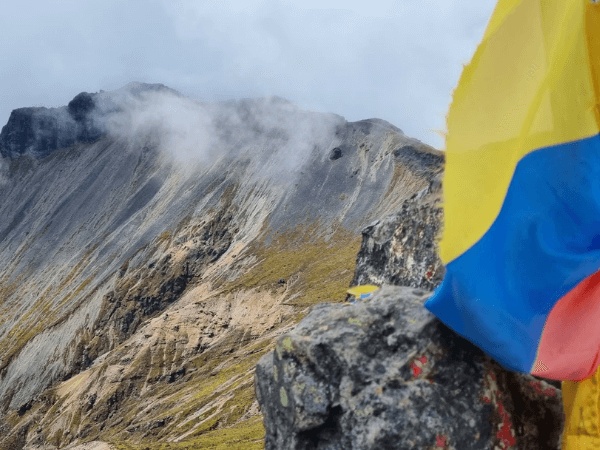 Blick auf La Cumbre del Imbabura, 4640 Meter hoch, zusammen mit der Flagge Ecuadors. Symbol für die Bedeutung von Pacha Mama und Buen Vivir im aktuellen Rechtsrahmen. Foto: Sarah Allegaert, Unsplash