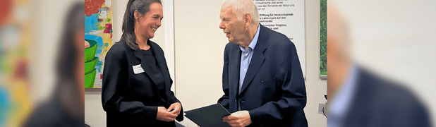 Georg Winter übergibt Tina Rametsteiner die Auszeichnung für ihre Dissertation zu den internationalen Rechten der Natur.