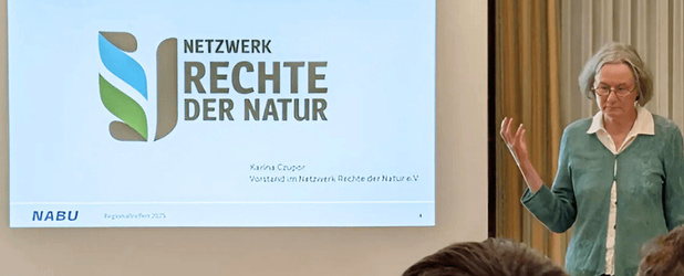 Vorstandsmitglied Karina Czupor hält für den NABU einen Vortrag des Netzwerks Rechte der Natur vor einer PowerPoint-Präsentation mit den Logos von NABU und Rechte der Natur.