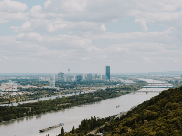 Wien aus der Luft mit Donau, Brücken und weitläufigen Grünflächen, Symbolbild für den Beitrag über Wirtschaft jenseits des Wachstums.